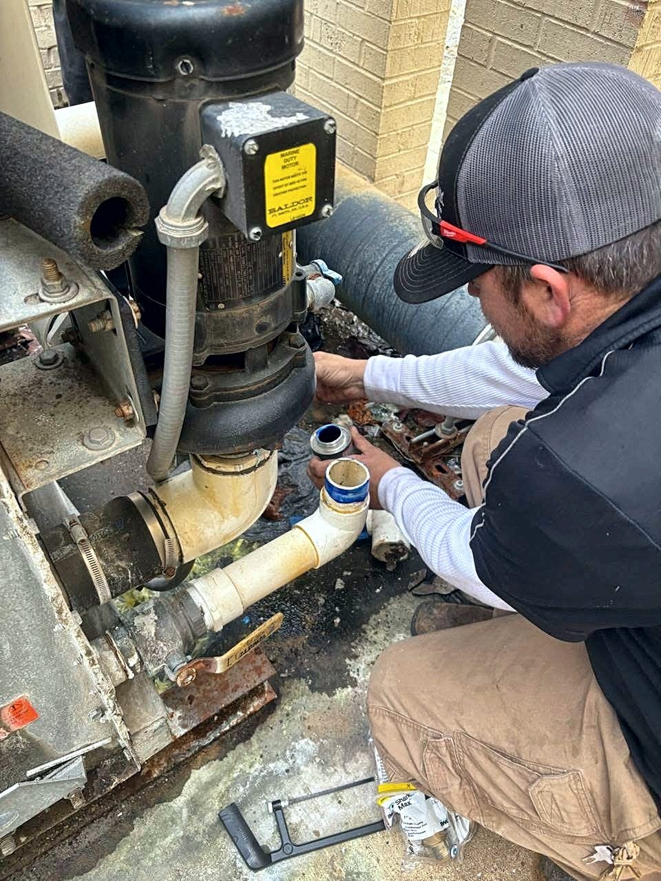 Glacier technician servicing a pump — real plumbing work in San Antonio
